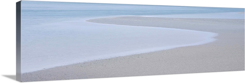 A photograph of a long beach on a hazy day.