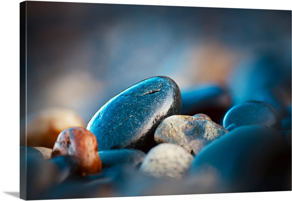 Pebbles on a beach on Vancouver Island, British Columbia, Canada. The small rocks reflect the very early morning colours, ...