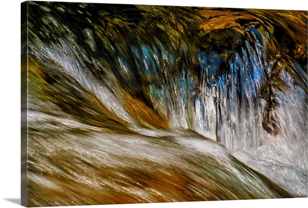 A photo of a running water with a reflection of a blue sky.