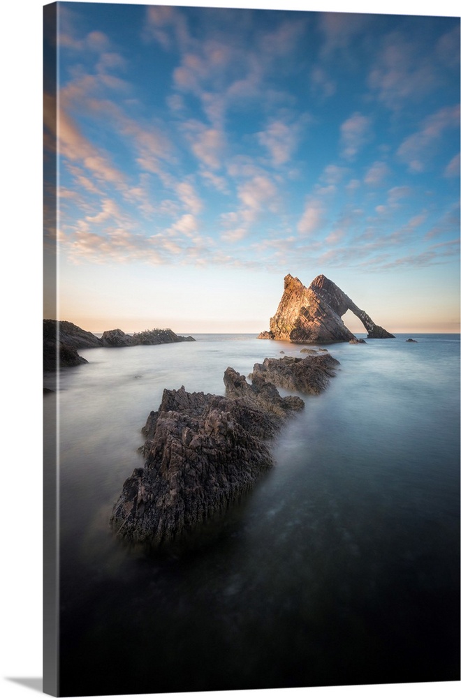Natural arch Rock in the middle of the sea at sunset in scotland north coast
