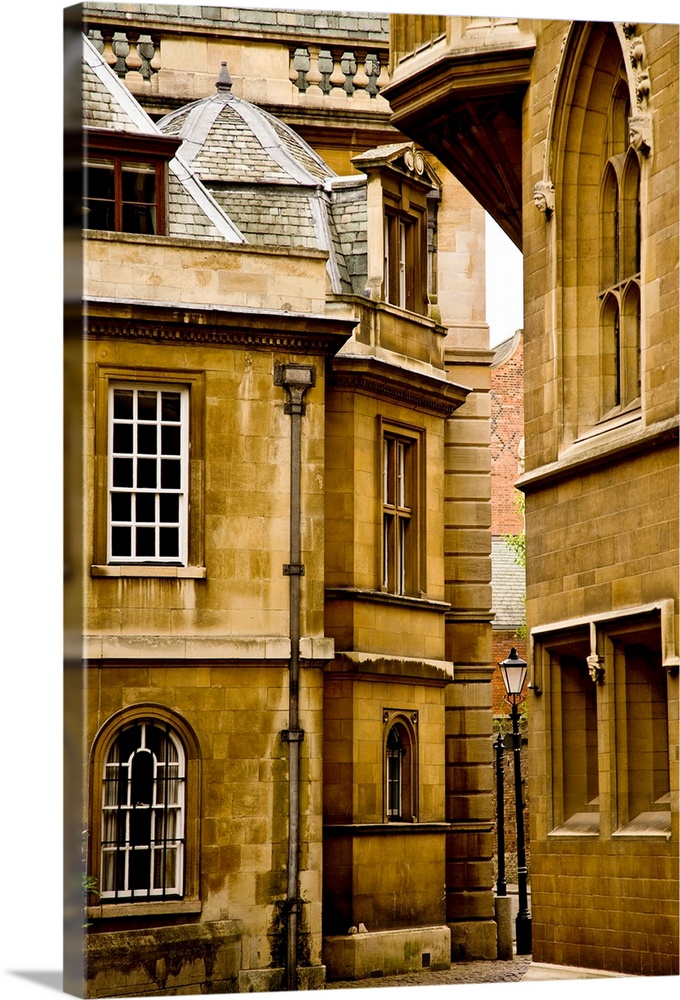 A view of ancient buildings in yellowed stone in Cambridge, England.