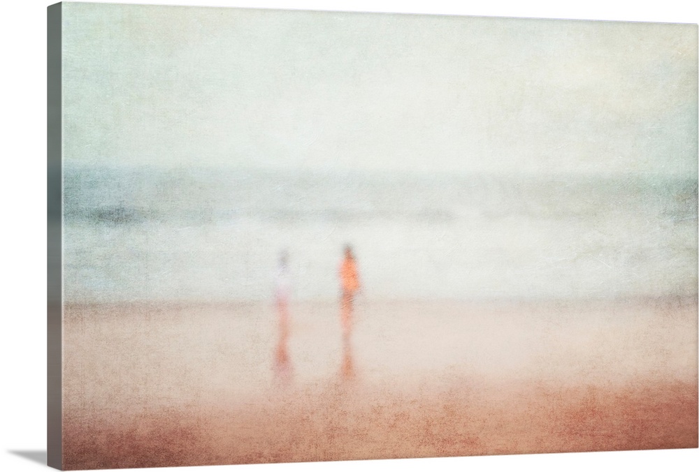 A vintage seaside holiday vacation dream image of two children playing on a beach in blurry soft focus.