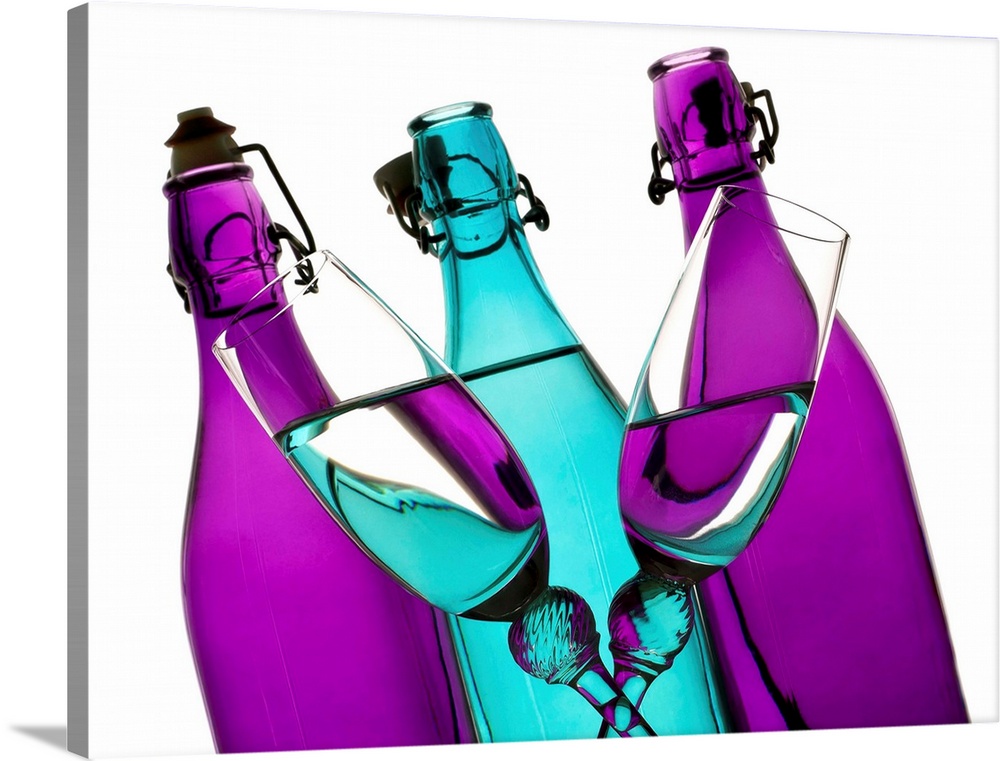 turquoise and purple glass bottles with two champagne flutes crossing in front on a white background.