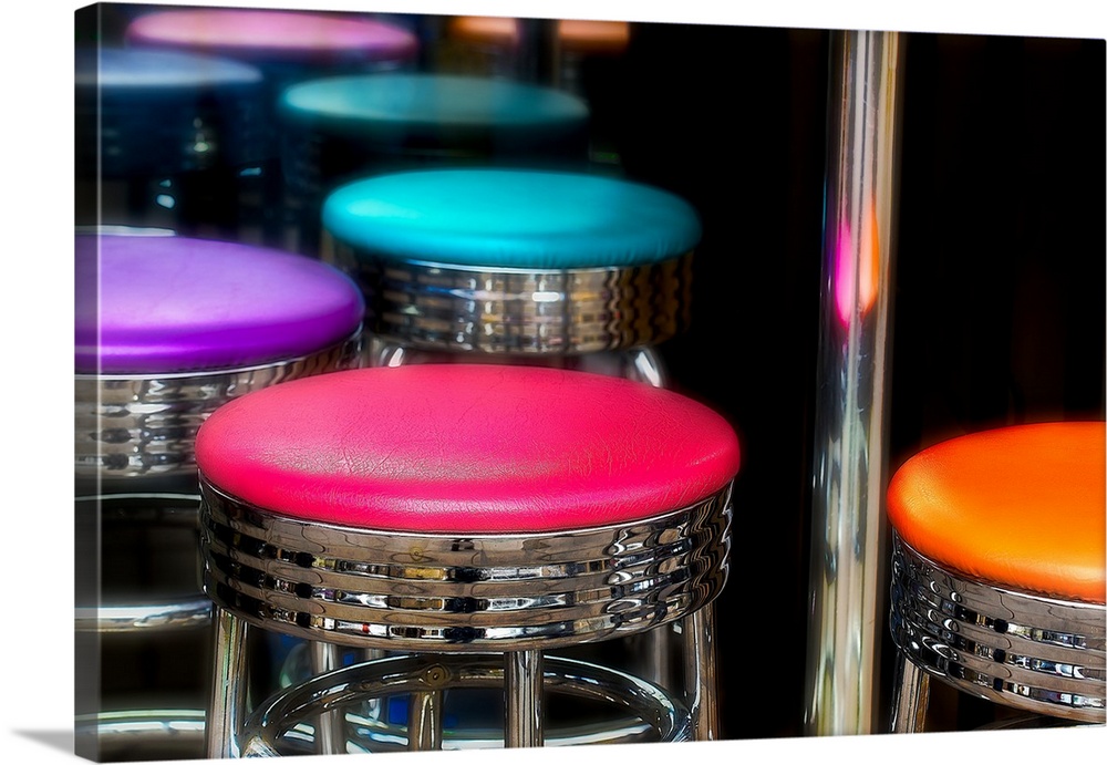 Brightly colored bar stools in pink, purple, teal, and orange, with chrome rims.