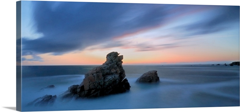 Pink and blue sunset on a shorecoast in Brittany in France, Quiberon area called cote sauvage, during summer, two rocks in...