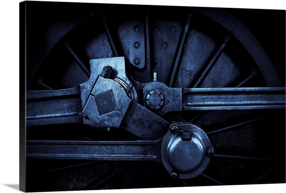 A close up in blue tone of a steam engine main crank wheel.