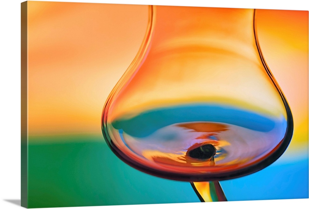 Abstract photo of a wine glass reflecting warped colors.