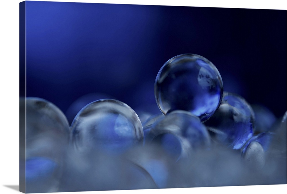 A macro photograph of a stack of blue clear spheres.