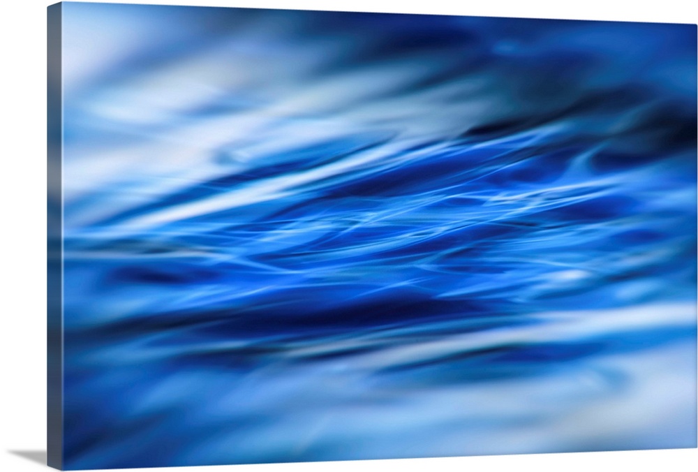 Abstract photograph of moving blue water with white highlights and a blurred vignette.