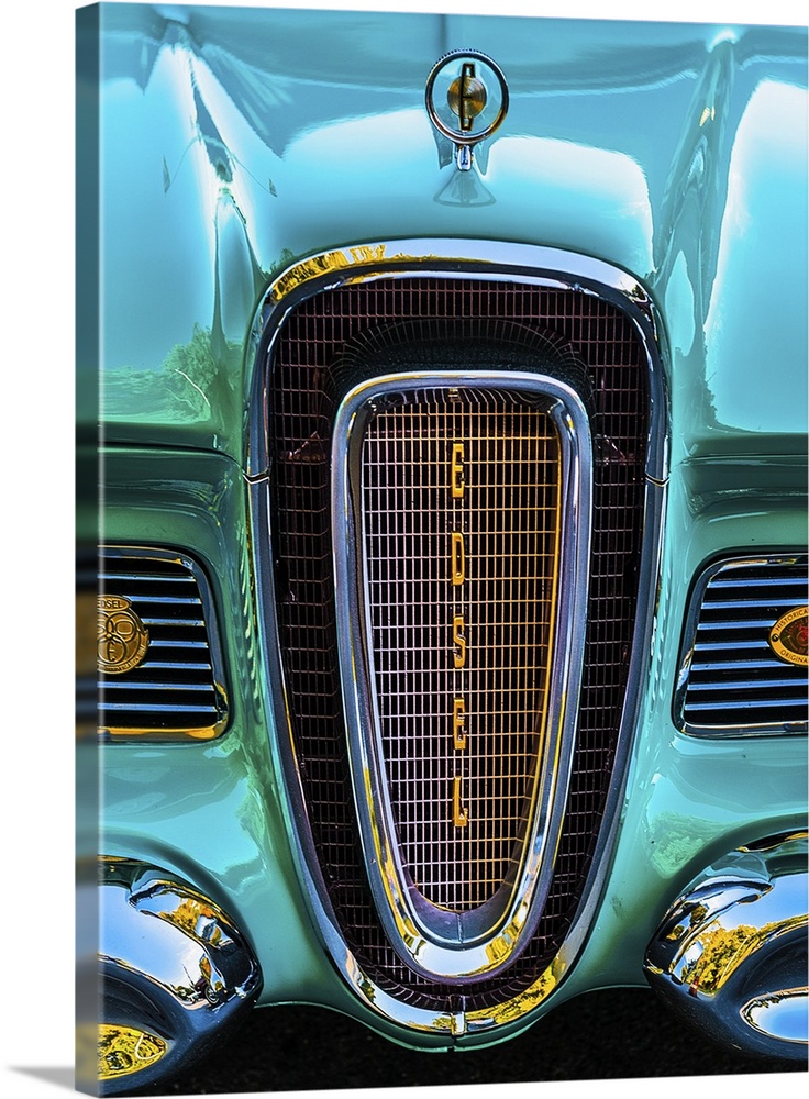 The front grille of a bright turquoise vintage car.