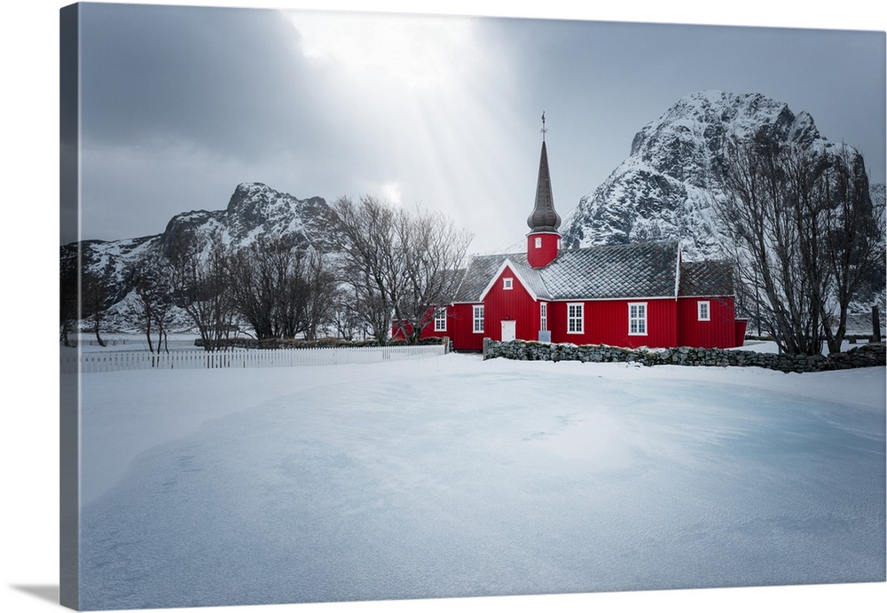 A photograph of red church seen in a wintry landscape.