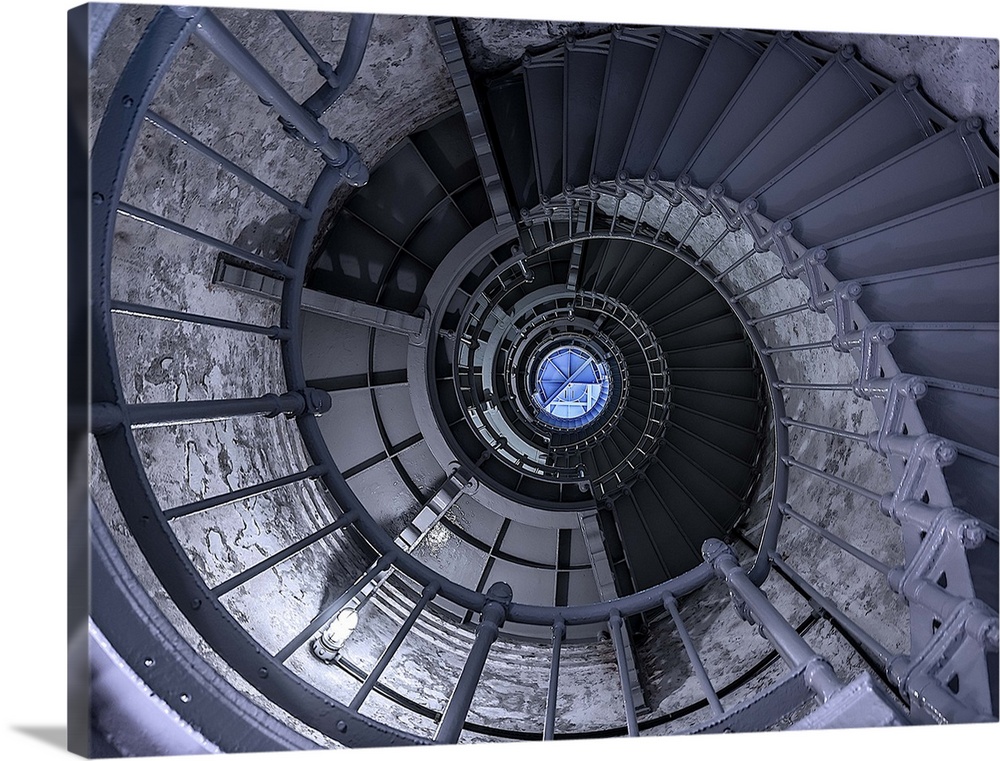 View through a spiral staircase to the top of a lighthouse.