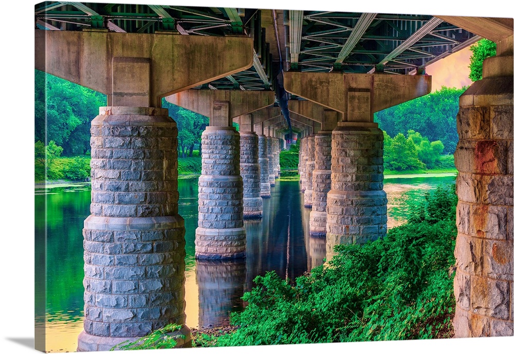 Stone pillars under a bridge, standing in the water.