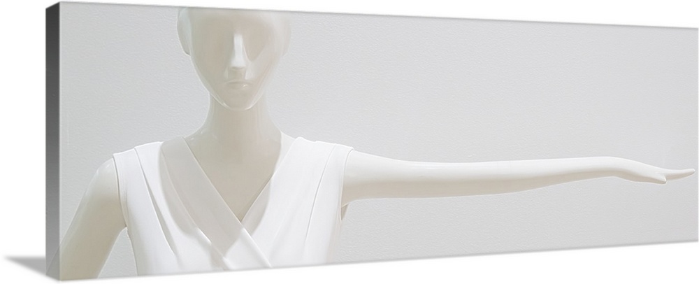 White mannequin wearing a white outfit blending into a white background.
