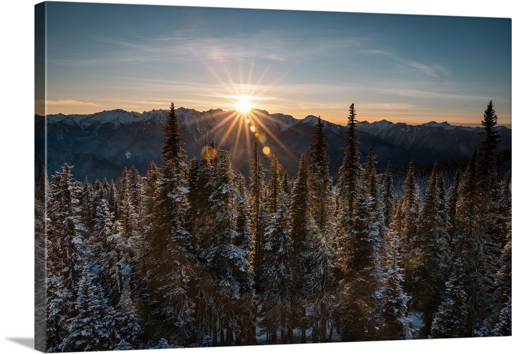 Beam of sun light over snow mountains at Hurricane Ridge, Olympic National Park, during sunset.