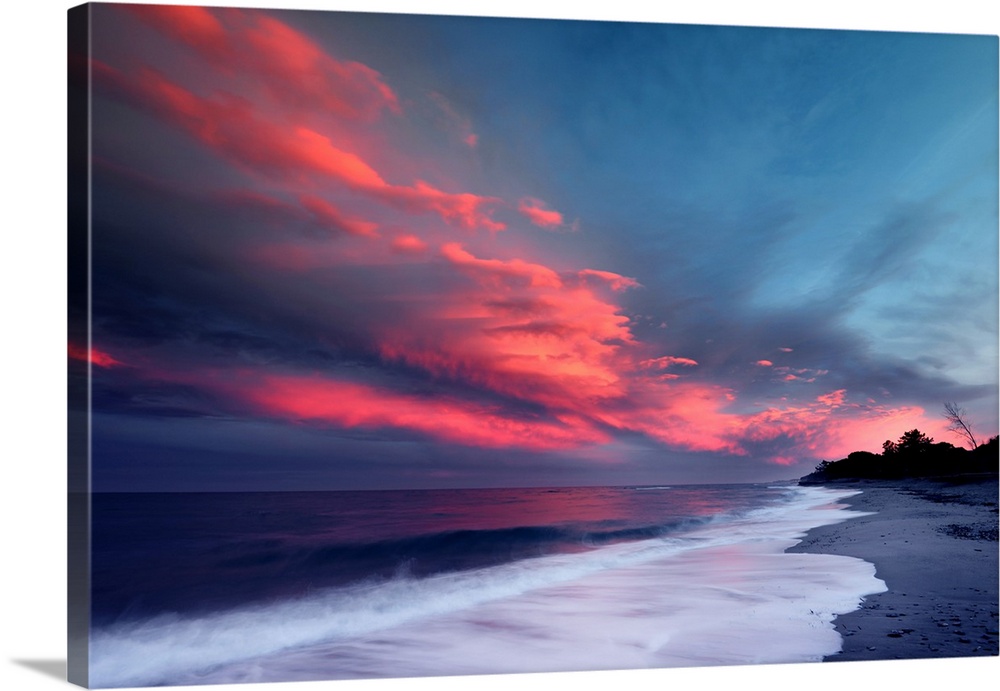 Sunset over the Atlantic ocean with brilliant red clouds over white capped waves