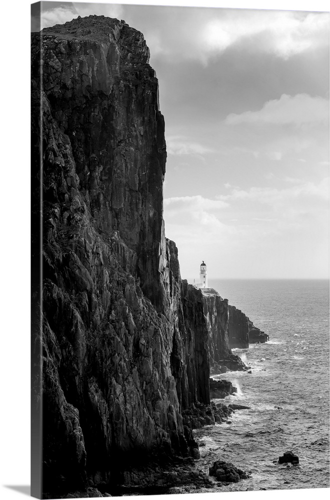 Fine art photo of a steep ocean cliff with rocks below, in black and white.