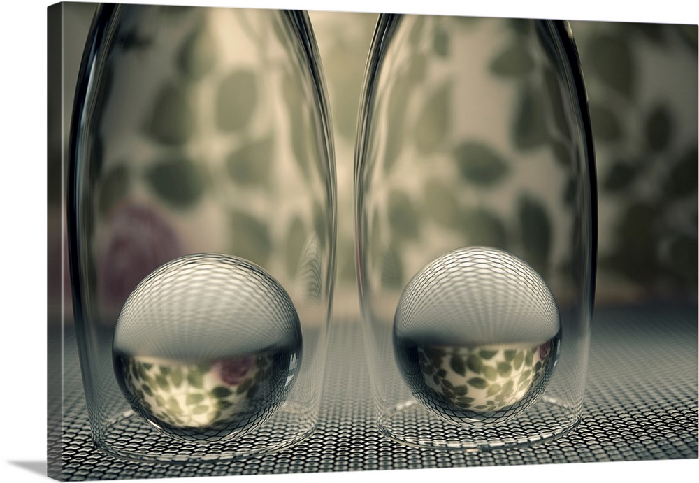 Two glass marbles underneath champagne flutes reflecting the bottom  surface and background onto them.