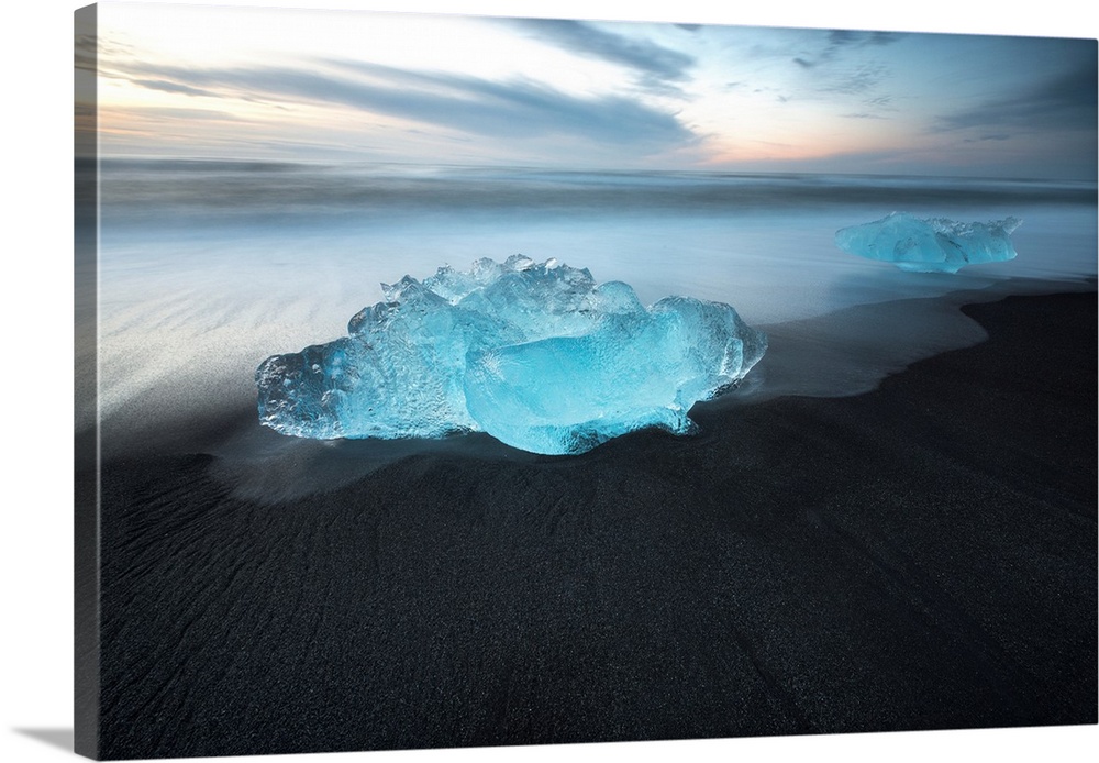 Bright blue glacial ice on a black sand beach in Iceland.