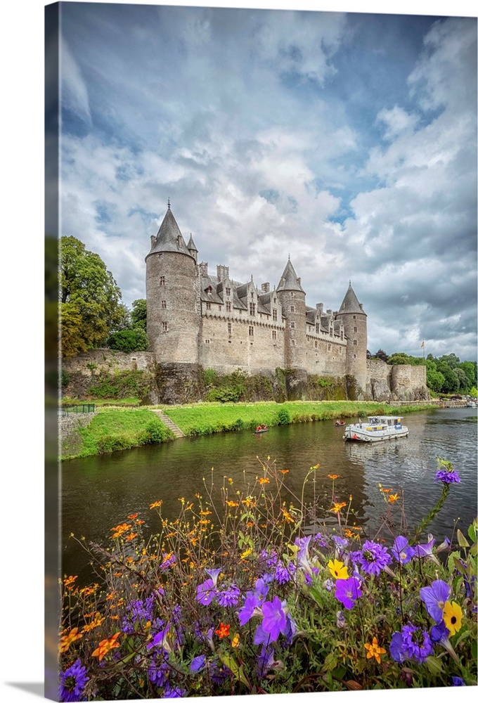 View of a medieval castle from across the river with flowers.