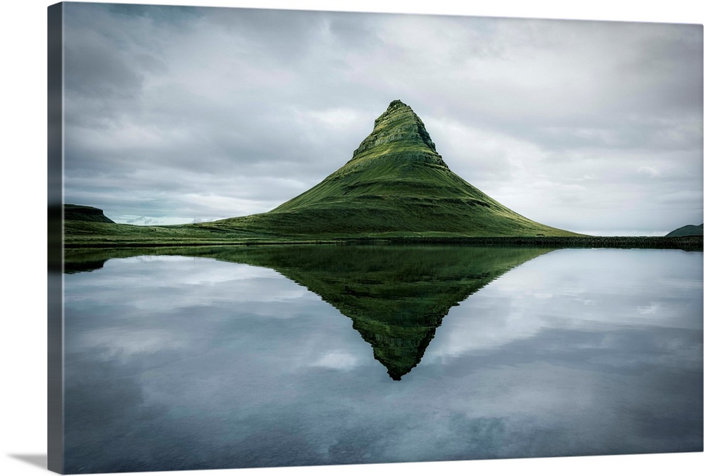 Fine art photograph of the tall peak of Kirkjufell overlooking a calm lake in Iceland.