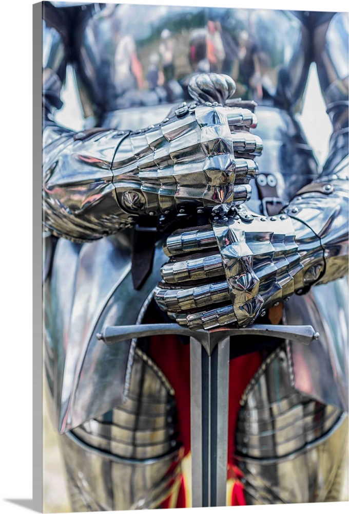 A photograph of a close-up on a suit of armor holding a sword.