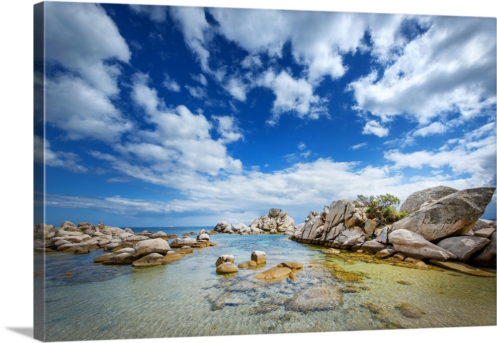 A photograph of a rocky coastline under a sky filled with dramatic clouds.