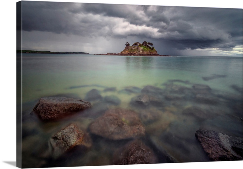 Long time exposure of the shorecoast of Ile du Guesclin island and castle in Brittany, a view at high tide with rocks at f...