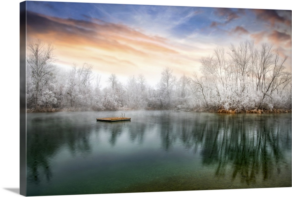 Photograph of a cold sunset across from a lake lined with frozen trees.