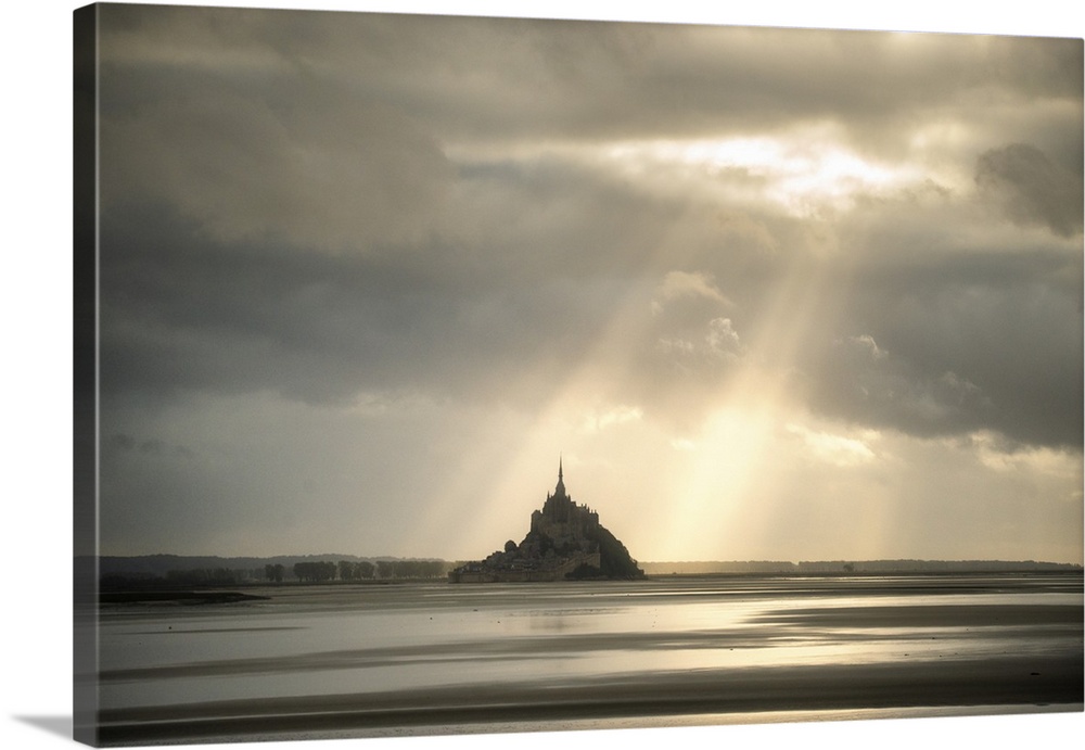 Mont saint michel in normandy, France, before sunset! Sun rays passing throw the grey clouds giving a biblic style to the ...