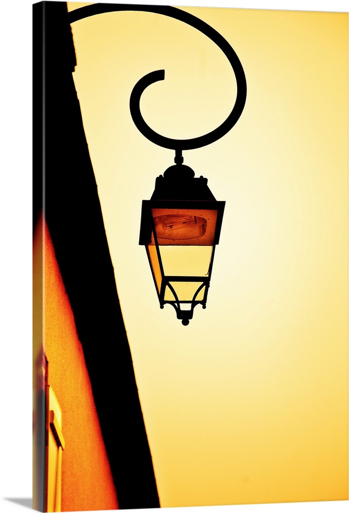 A glowing golden yellow sky with a vintage wrought iron gas lamp.