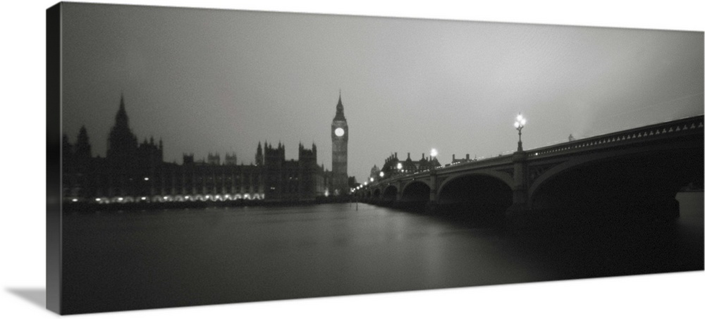 A monochrome black and white sepia toned night time image of the Houses of Parliament, London, England from the River Thames.