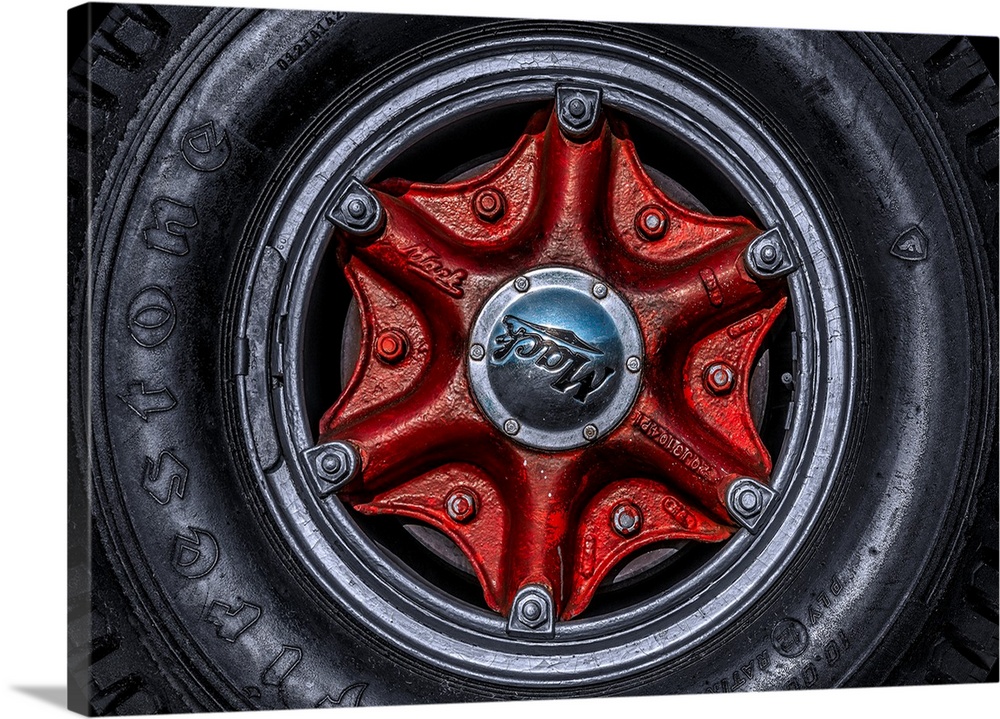 Large tire and red hubcap of a Mack truck.