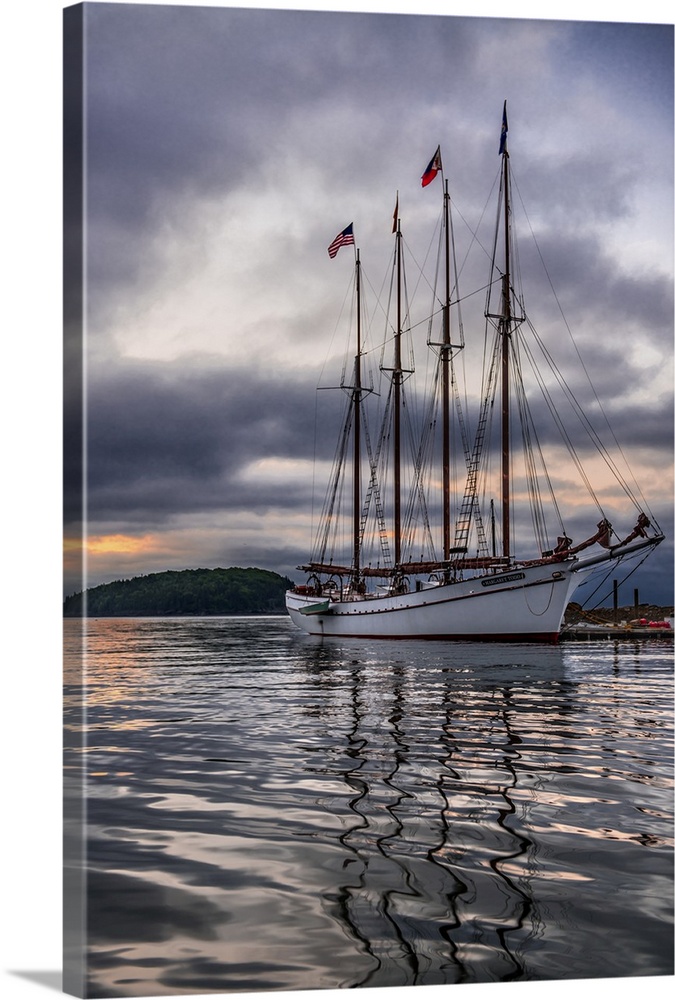 Beautiful sailing ship Margaret Todd rests at it's pier amidst a dramatic atmospheric sunrise in Bar Harbor Maine.