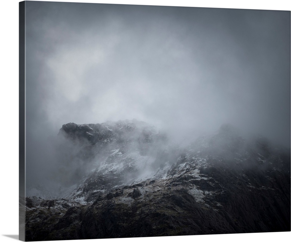 Fine art photo of the side of a mountain covered in a deep fog.