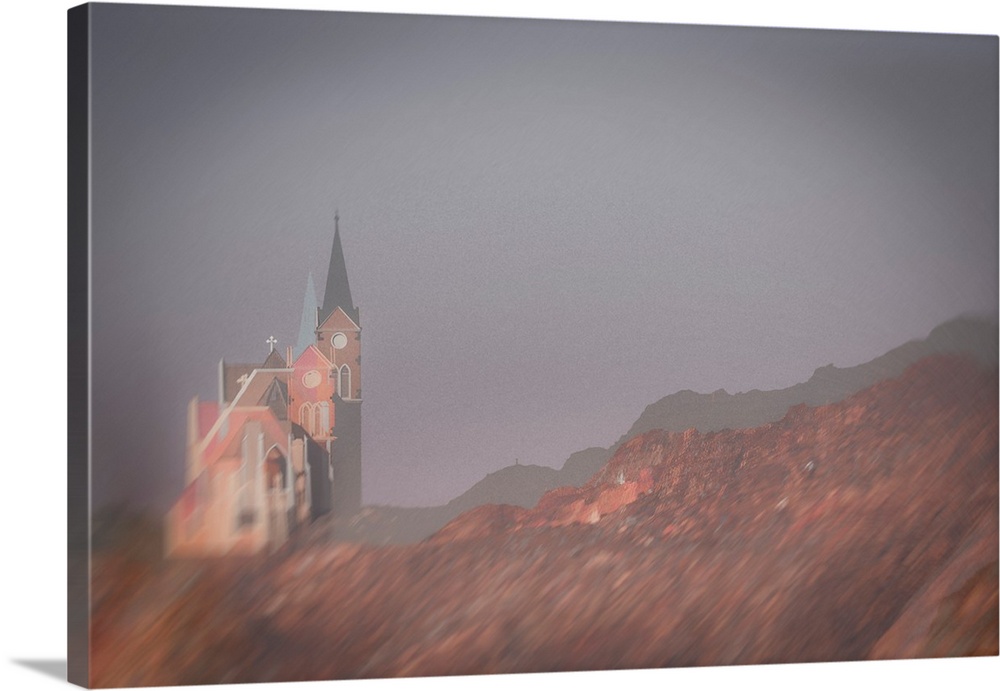 Multiple exposure image of a Namibian church on a mountain side with light vignetted corners.