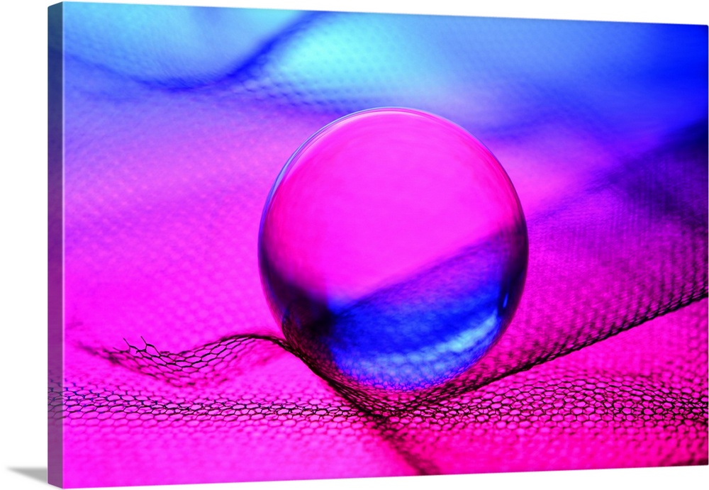 A glass sphere reflecting bright fuchsia and blue light.