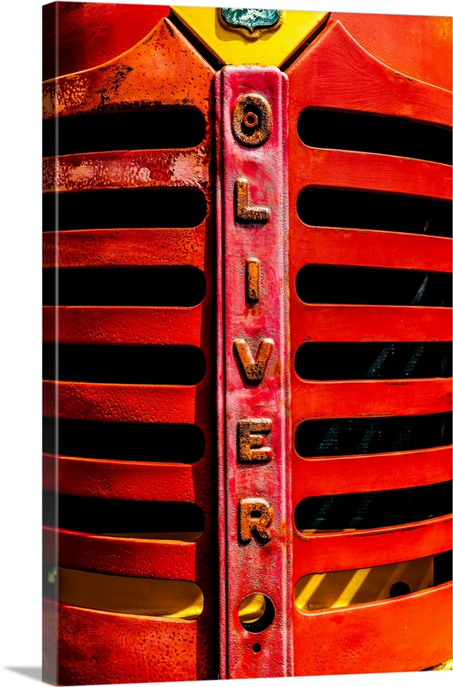 The red grill of a vintage tractor, with the brand "Oliver" printed in the metal.