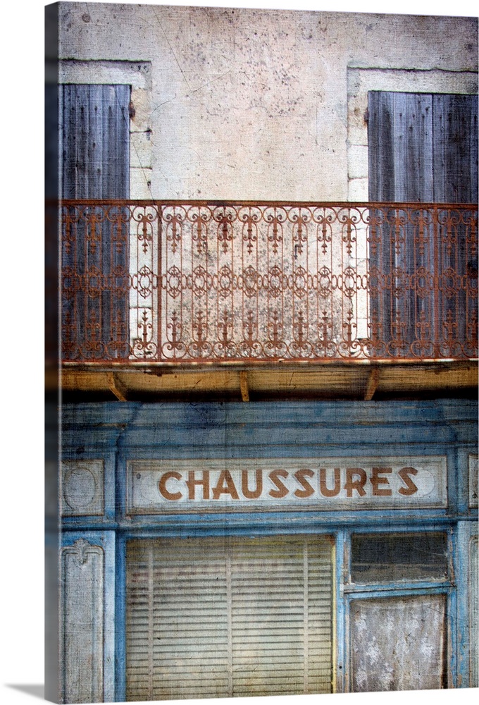 A vintage image of an old faded French shop front in Paris with a wrought iron balcony in blues and neutral tones.