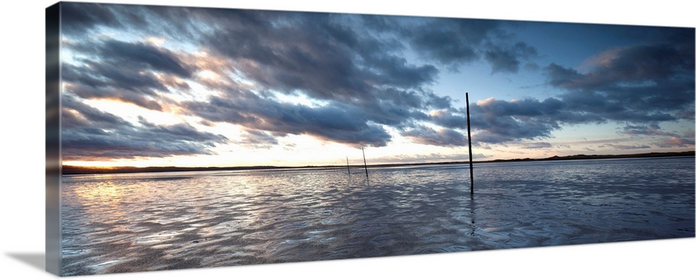 A Panoramic Sunrise over the Pilgrims Causeway at Lindisfarne on Holy Island, Northumberland, UK with fluffy clouds and go...