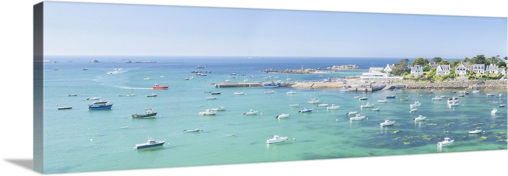 Panoramic landscape photography of Portsall bay in Brittany with boats and emerald sea on a sunny day.
