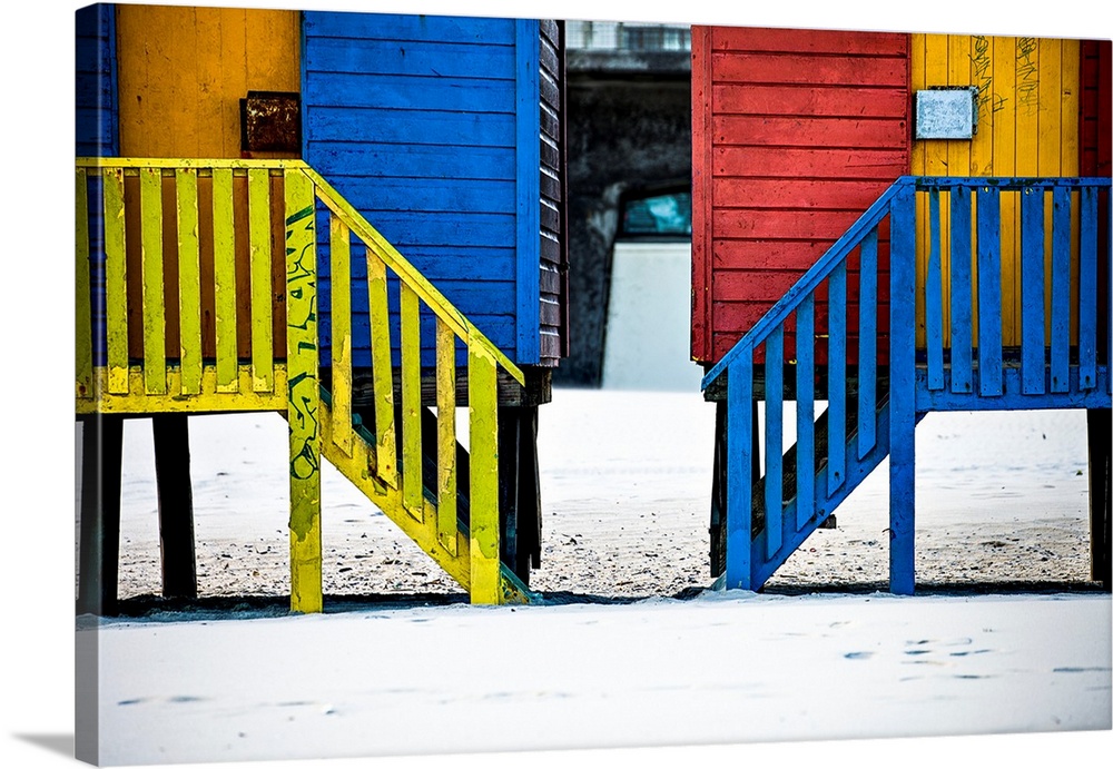 A photo of colorful buildings that have been painted in primary colors over a white snowy landscape.