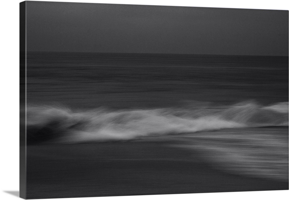 Artistically blurred photo. A calm sea. Waves rise from the undertow and break on the beach.