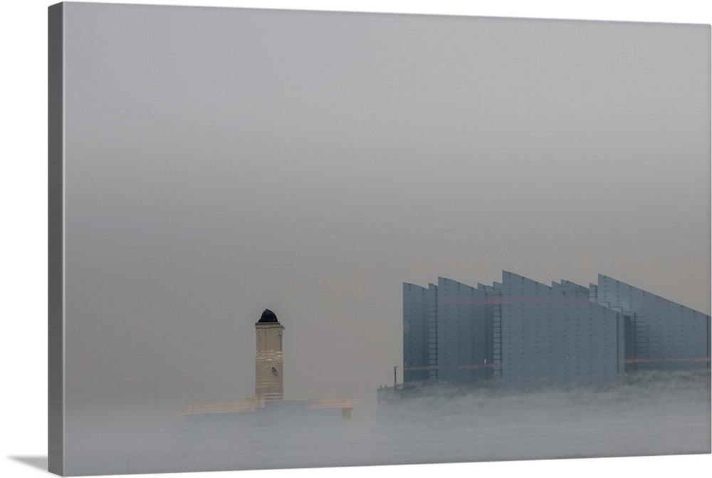 Fine art photograph of a repeated city building on a gray sky with mist at the bottom rising up.