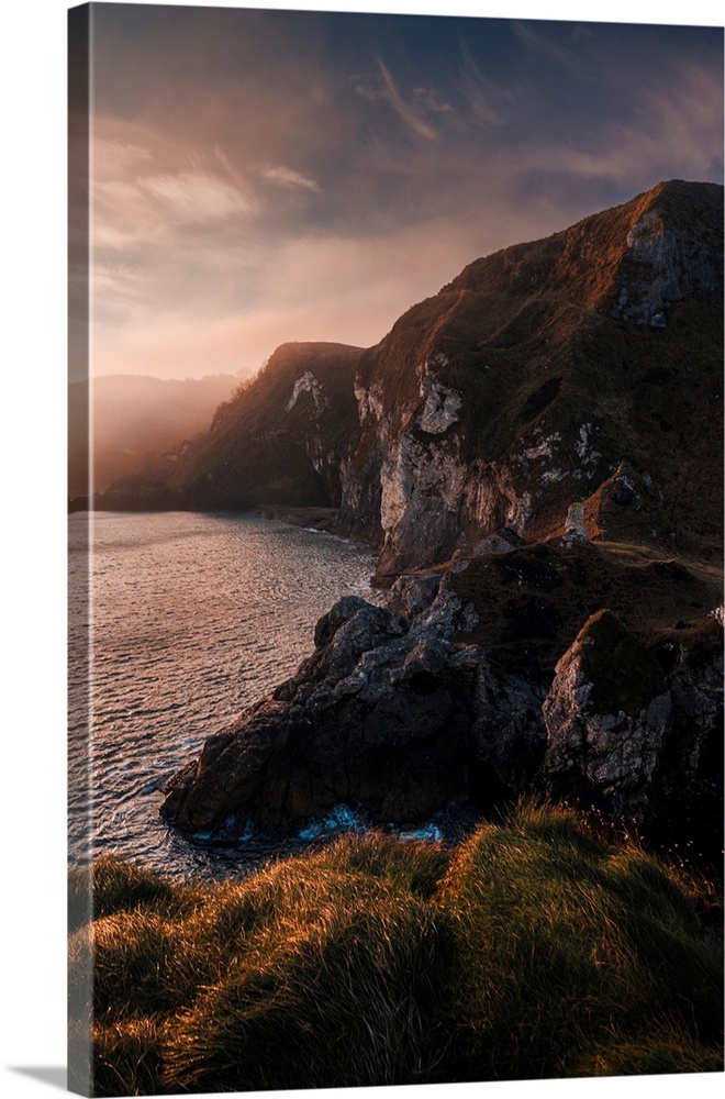 Rocky cliffs in the fog near Kinbane Castle in Northern Ireland during a winter sunrise.