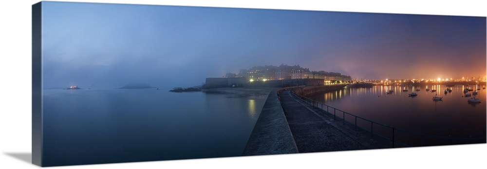 Panoramic view of Saint Malo city in Brittany at night with fog coming from the sea, blue and pink mood.