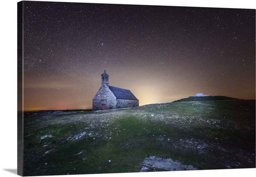 A church in a field in the evening with stars in the sky.