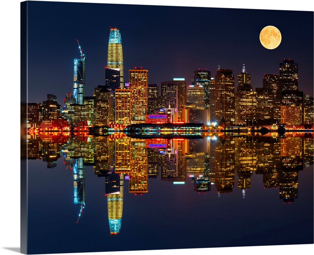 Photograph of the city skyline of San Francisco reflecting in the Bay at night.