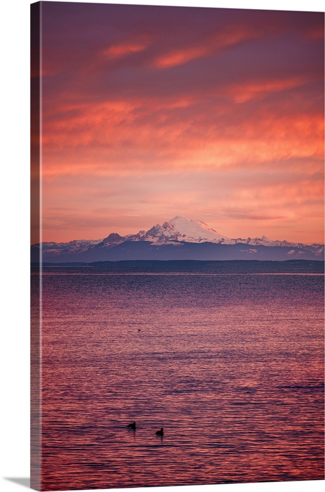 Mt Baker under the fiery sky before sunrise at Port Williams Beach in Washington State.