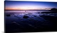 image thumbnail of A dramatic seascape at dawn with deep purple magenta pink skies and clouds over wet sands.